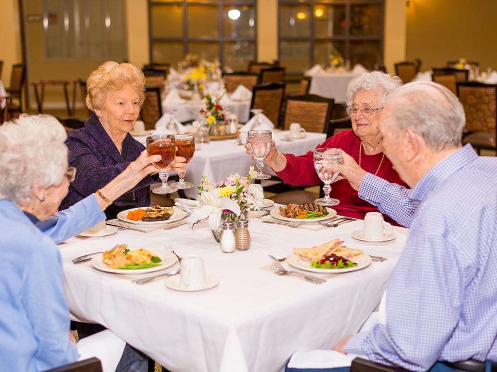 group of residents toasting each other while dining