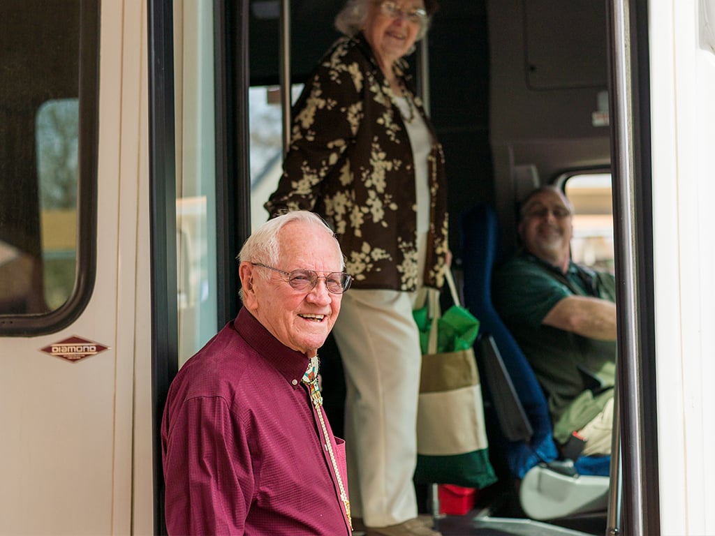 senior resident embarking on a trip in community bus